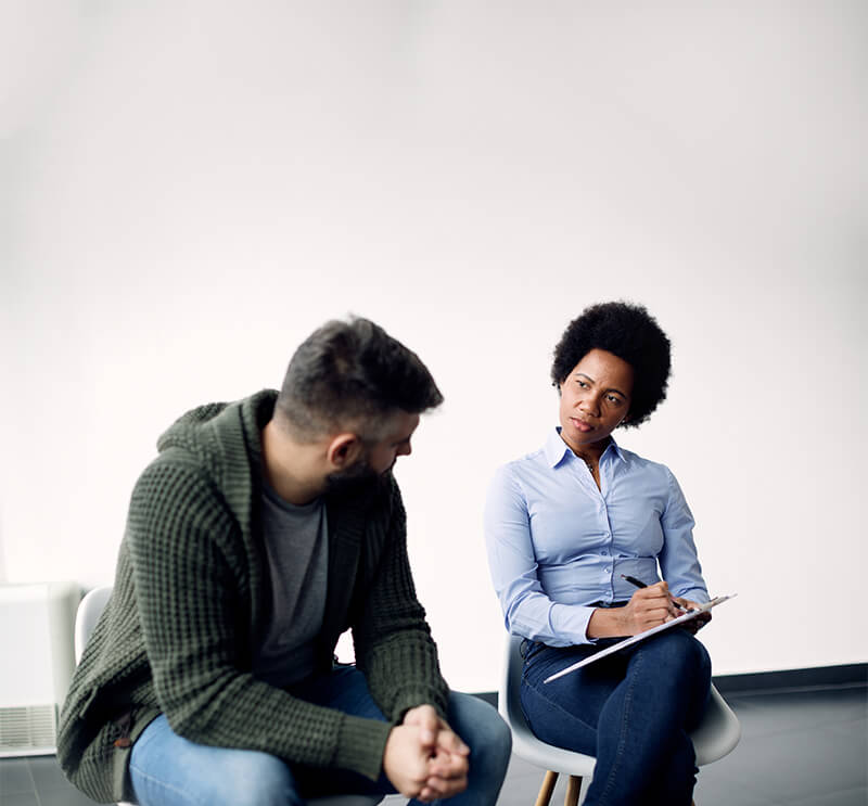 Therapist listening to her patient and taking notes