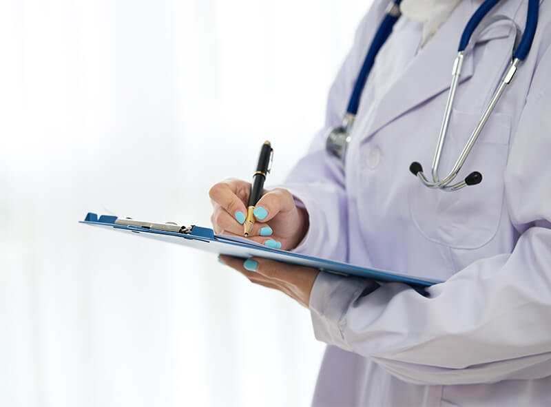 Doctor writing on a clipboard