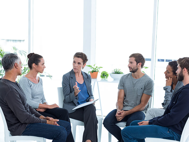 Therapist talking to a group of her patients